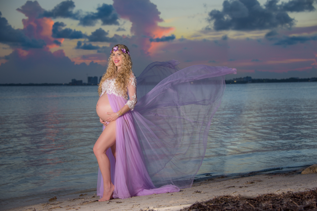 maternity picture mom holding belly by the beach sunset