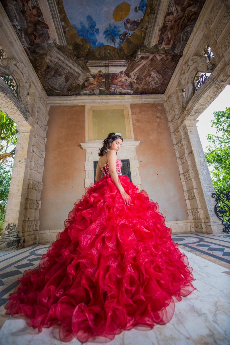 Quinceañera in green dress next to a pond